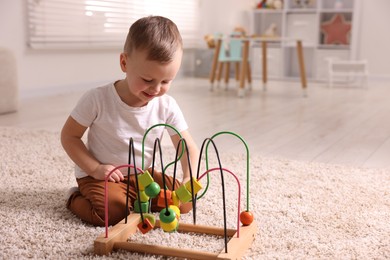 Motor skills development. Little boy playing with toy on floor at home