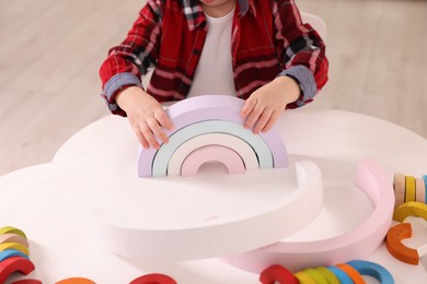 Motor skills development. Little boy playing with toys at white table indoors, closeup