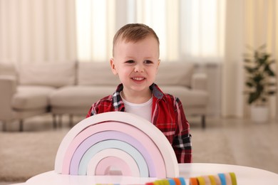 Motor skills development. Little boy playing with toys at white table indoors