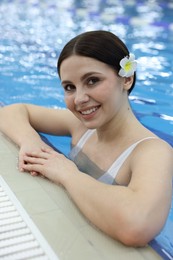 Beautiful young woman in indoor swimming pool