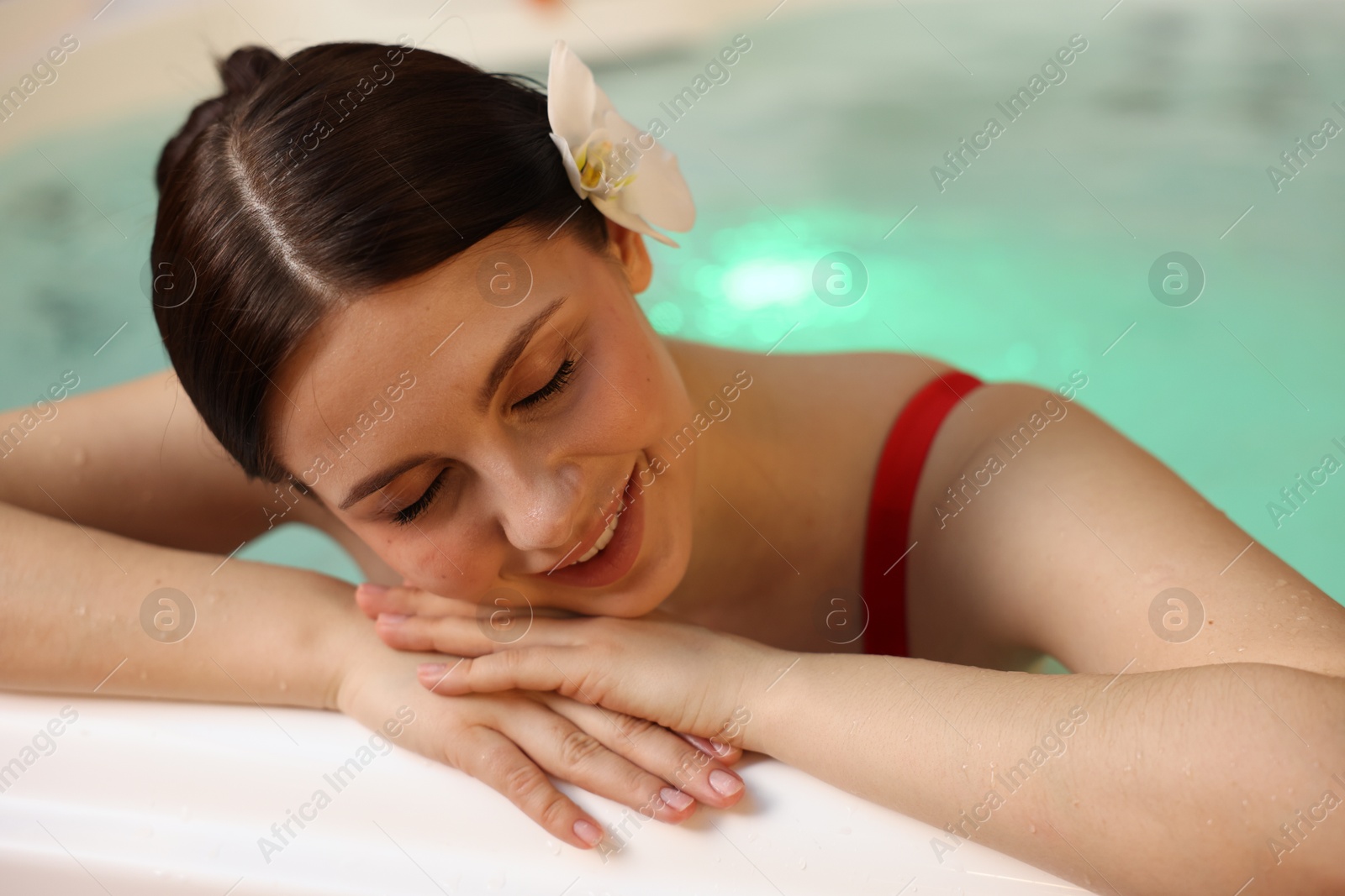 Photo of Beautiful woman relaxing in hot tub indoors