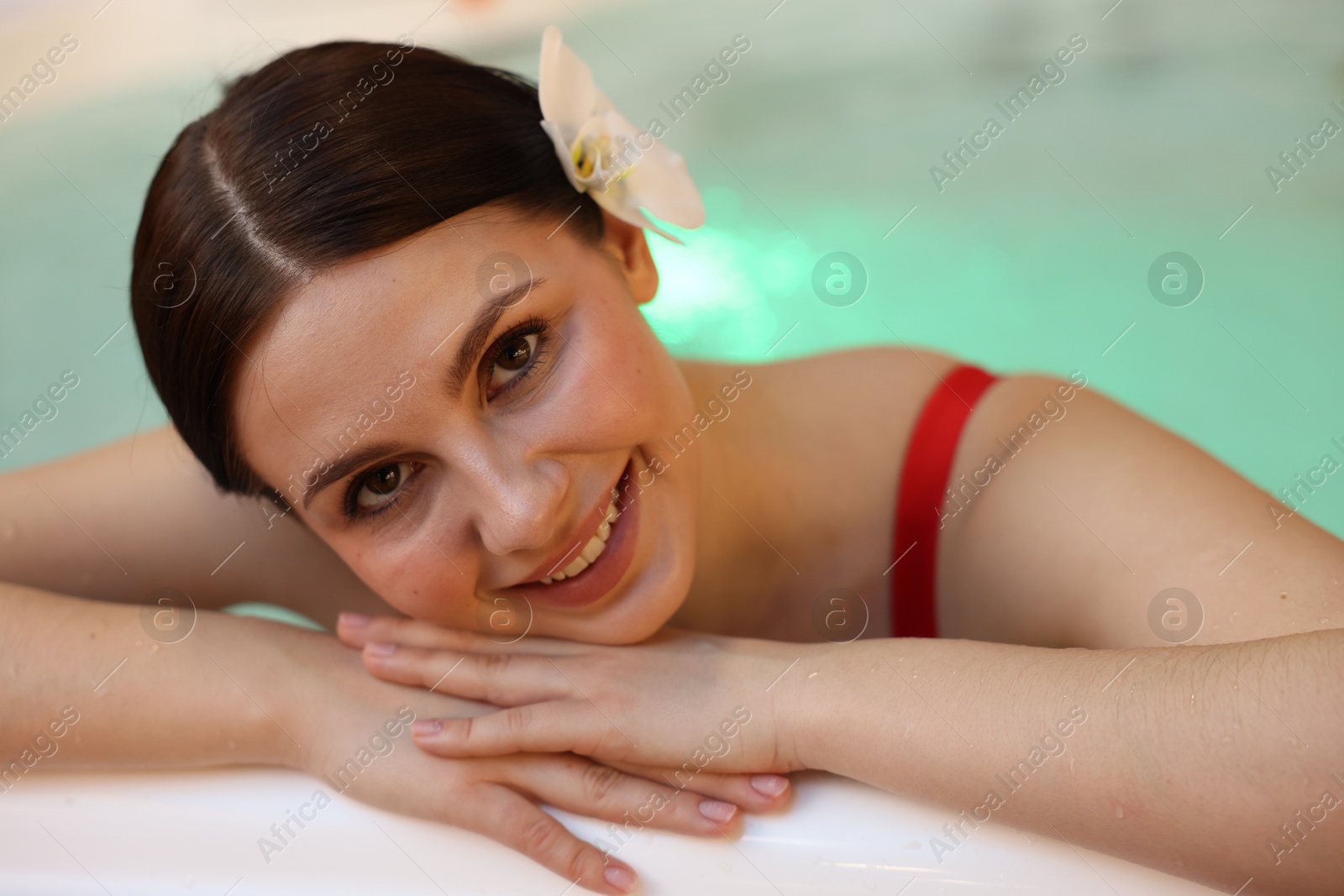 Photo of Beautiful woman relaxing in hot tub indoors