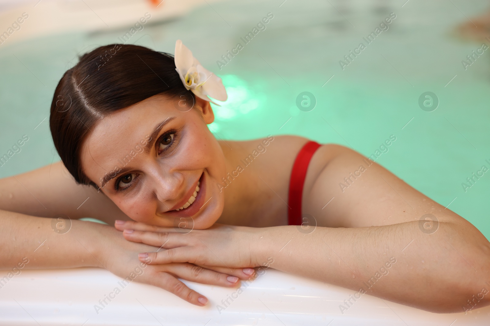 Photo of Beautiful woman relaxing in hot tub indoors