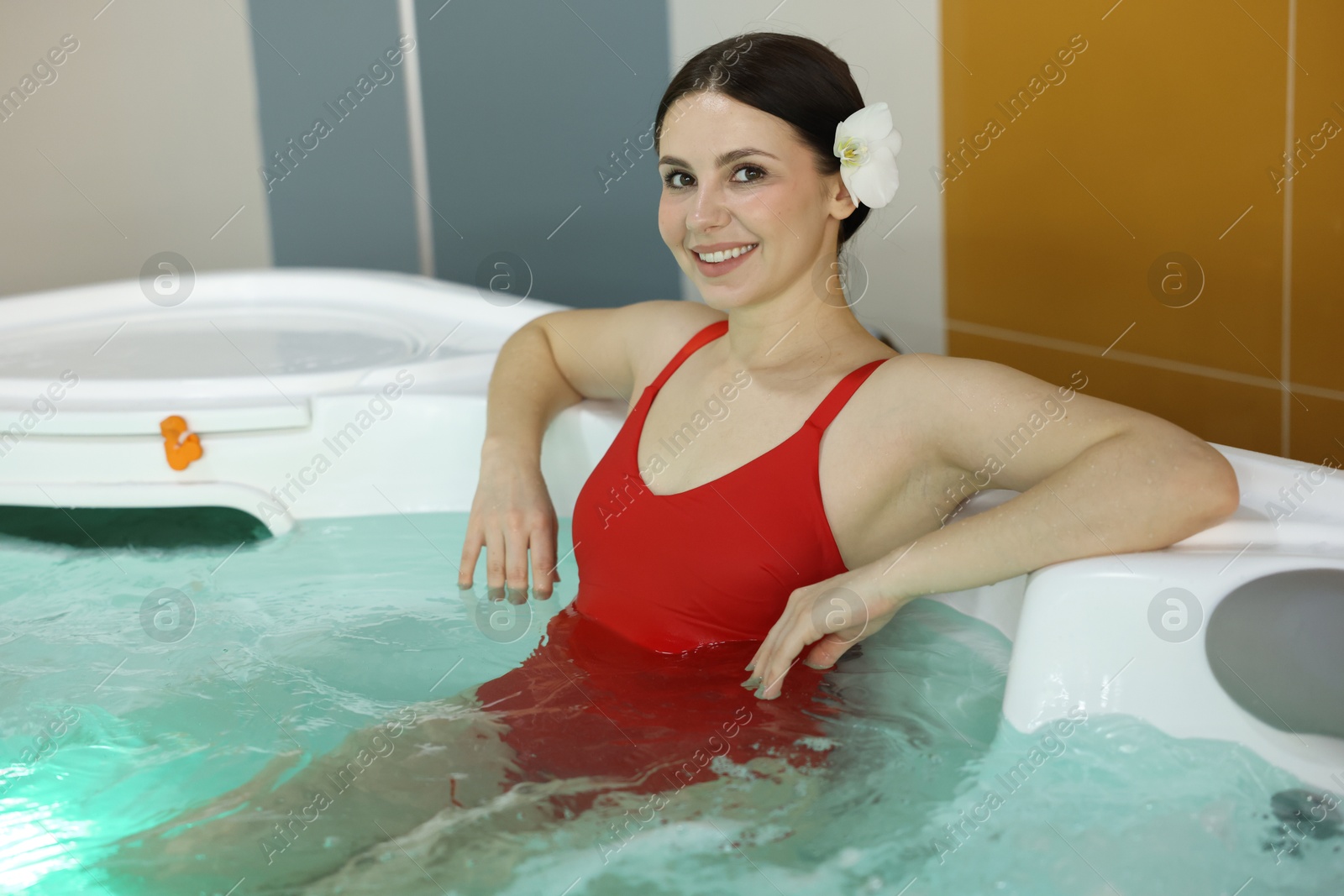 Photo of Beautiful woman relaxing in hot tub indoors