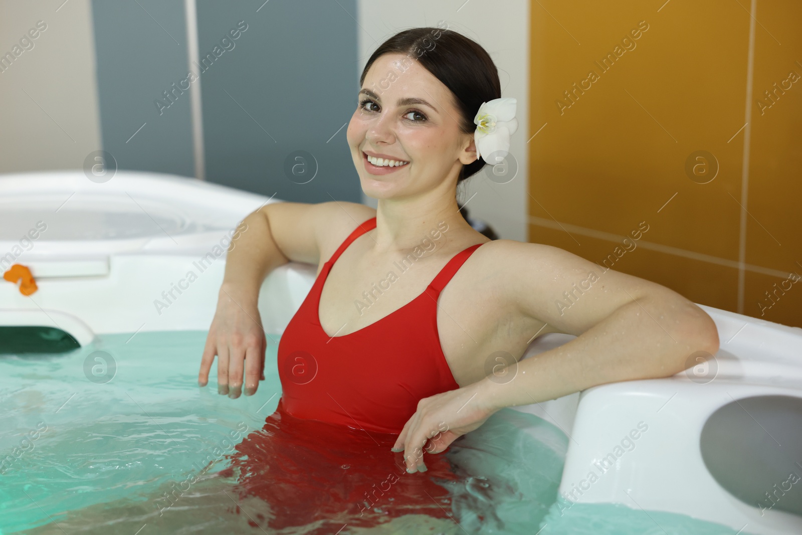 Photo of Beautiful woman relaxing in hot tub indoors