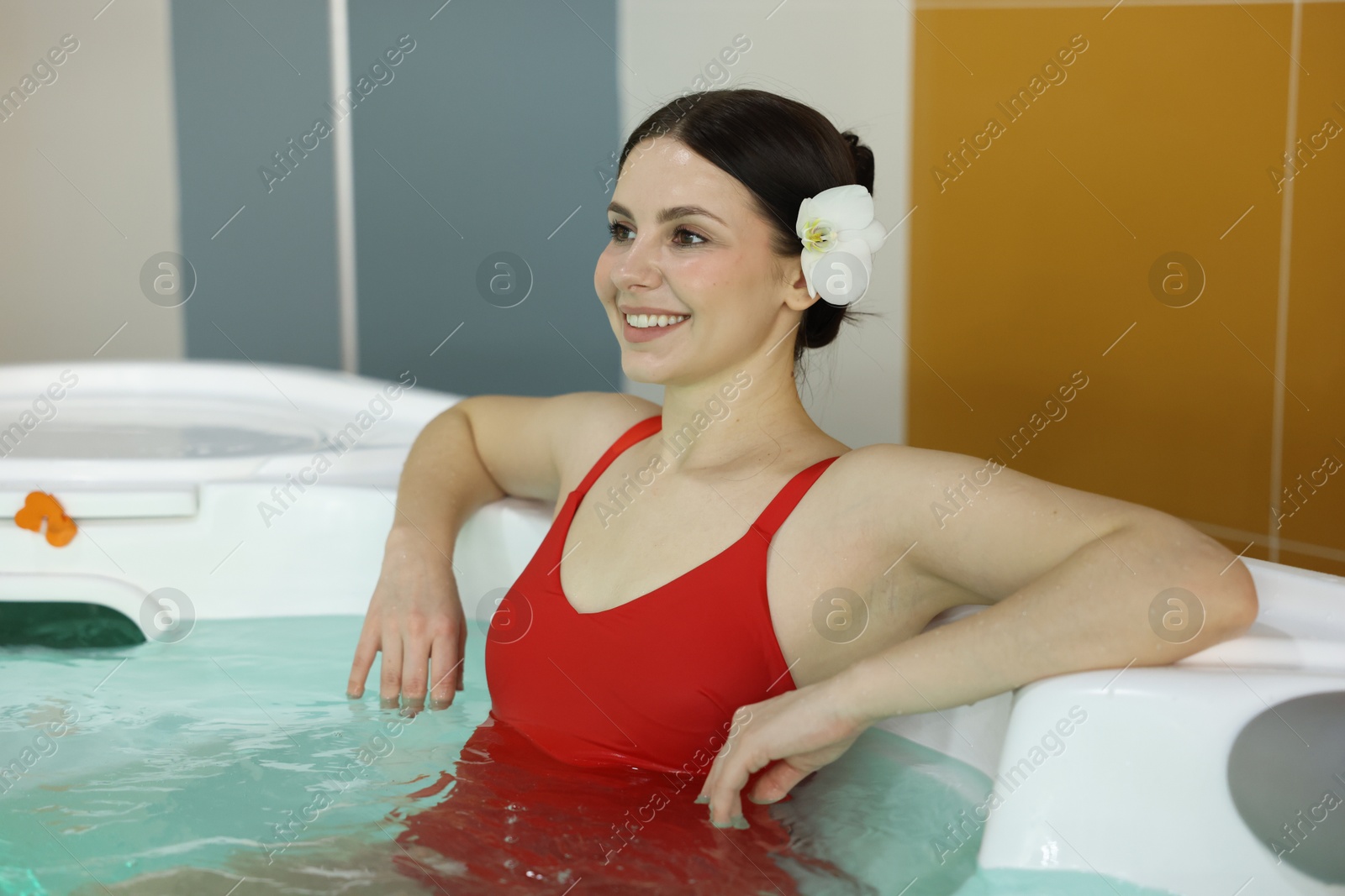 Photo of Beautiful woman relaxing in hot tub indoors