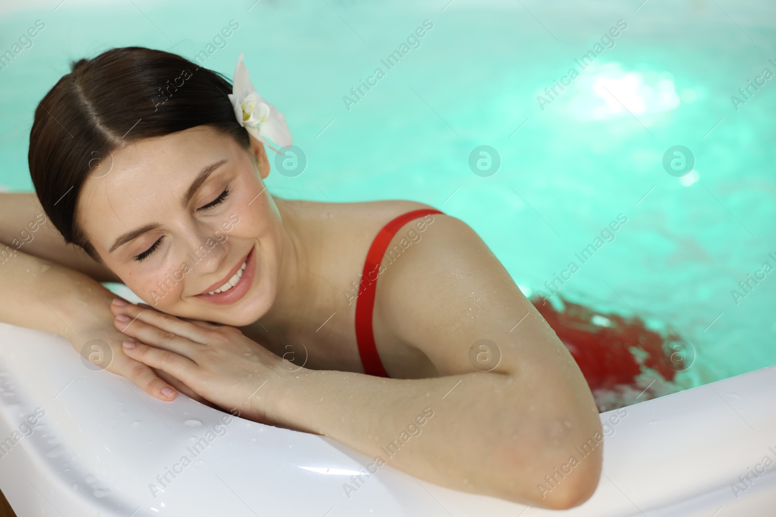 Photo of Beautiful woman relaxing in hot tub indoors