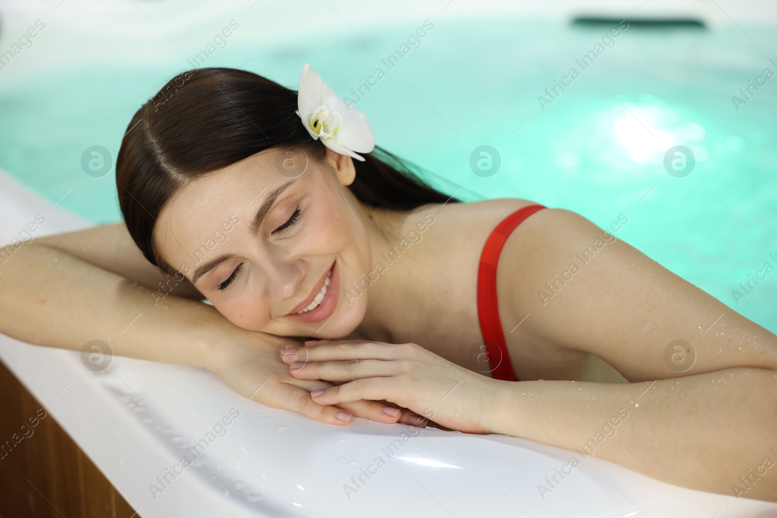 Photo of Beautiful woman relaxing in hot tub indoors