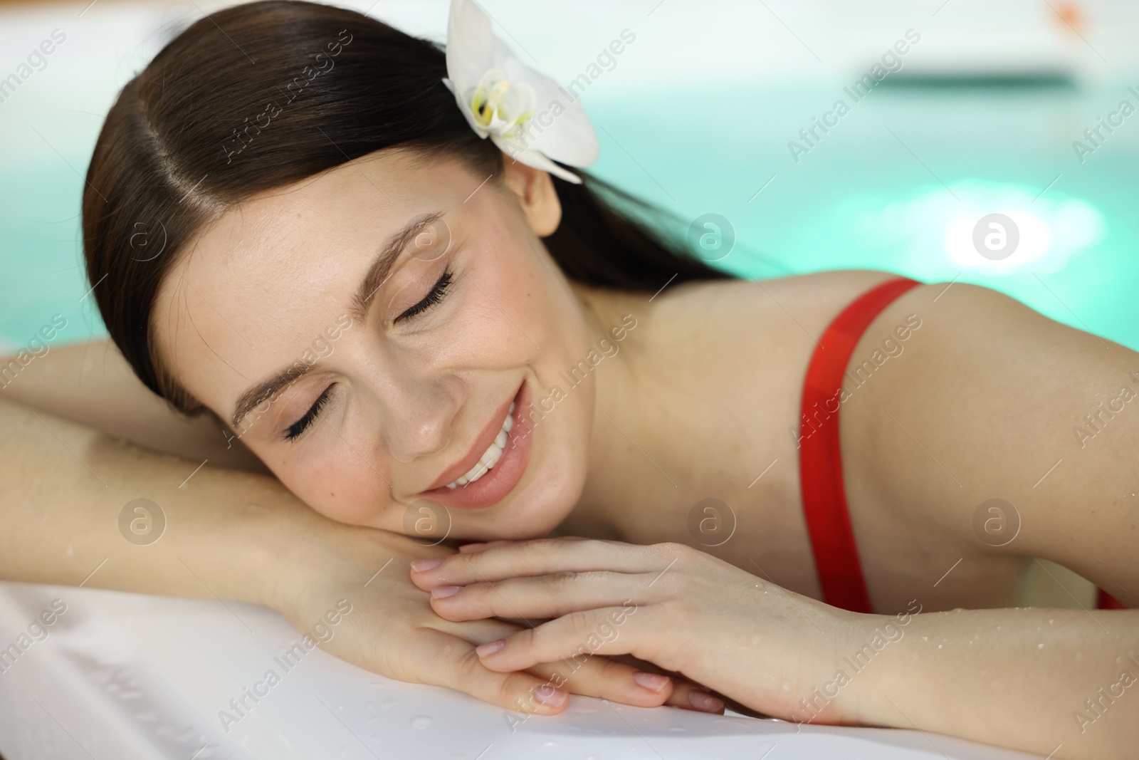 Photo of Beautiful woman relaxing in hot tub indoors