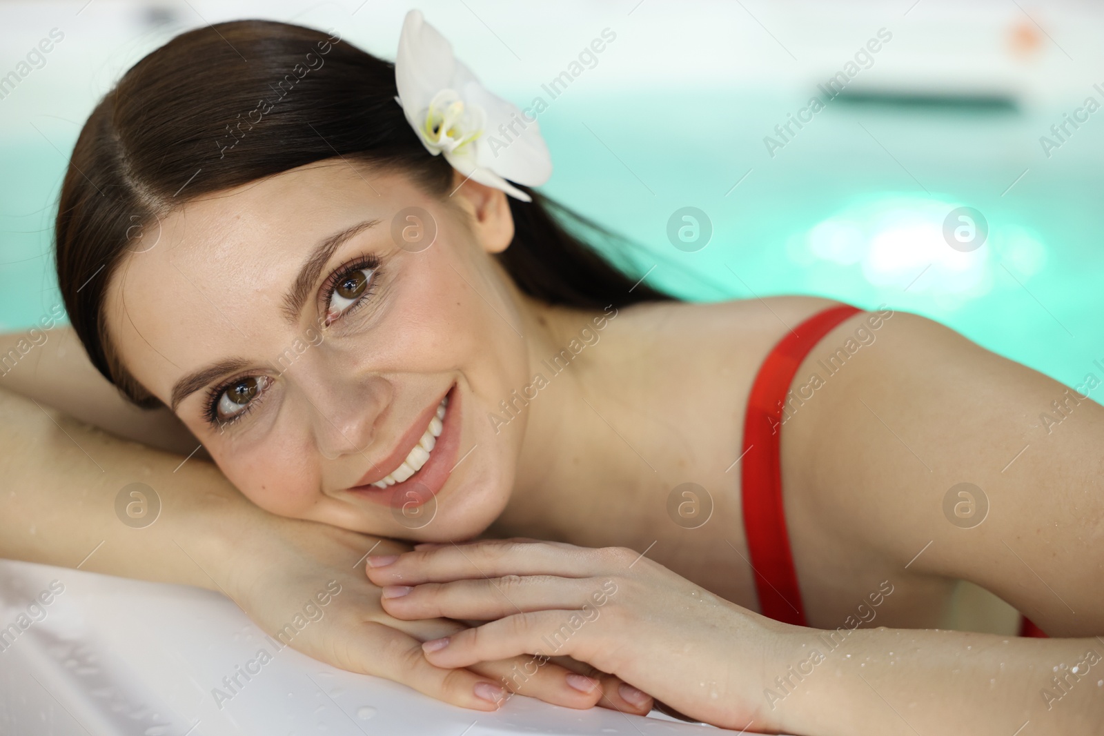 Photo of Beautiful woman relaxing in hot tub indoors