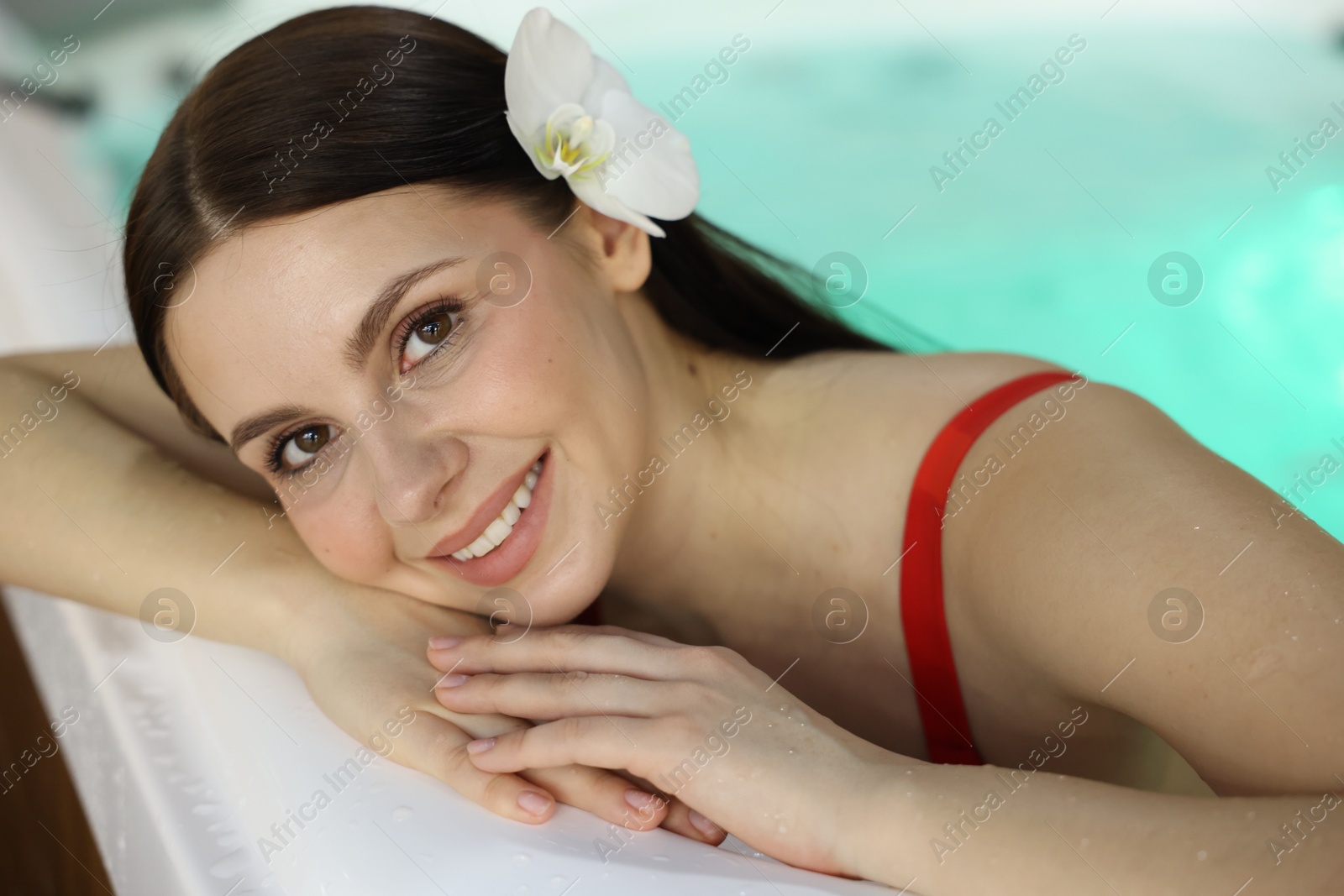 Photo of Beautiful woman relaxing in hot tub indoors