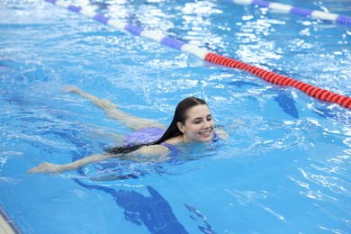 Photo of Beautiful young woman swimming in indoor pool