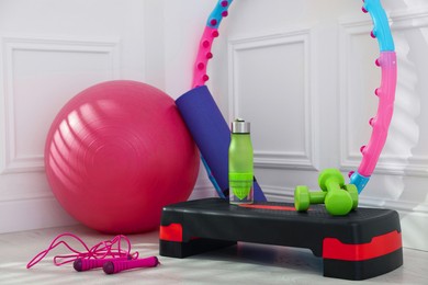 Photo of Different fitness equipment near white wall indoors