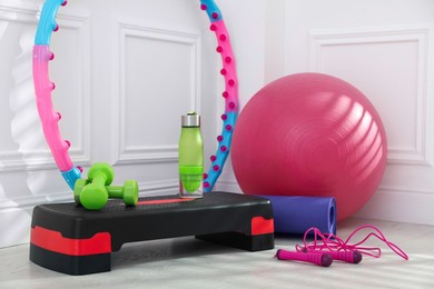 Photo of Different fitness equipment near white wall indoors