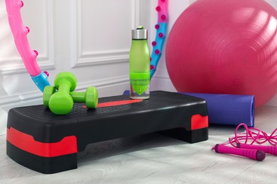 Photo of Different fitness equipment near white wall indoors