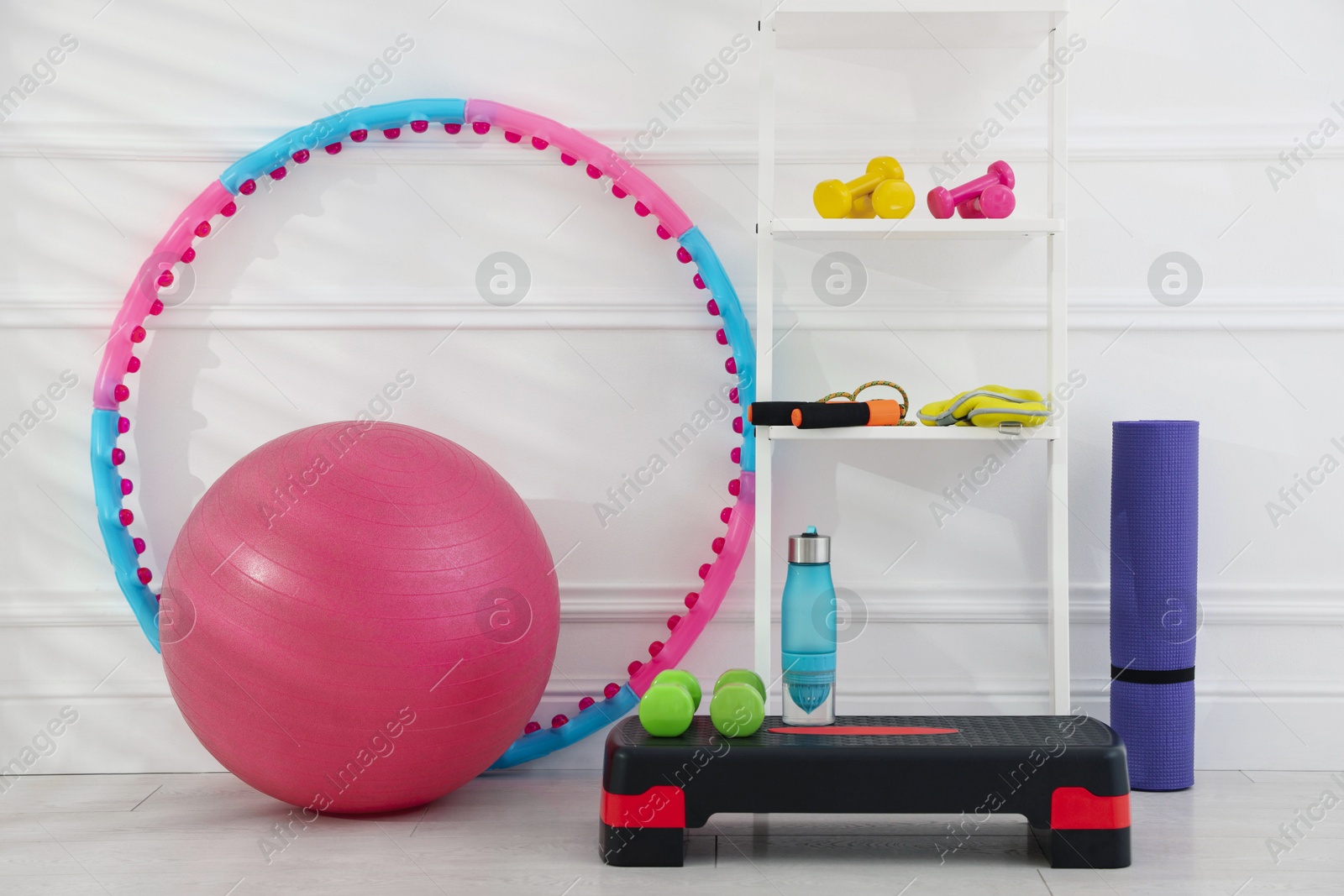 Photo of Different fitness equipment near white wall indoors