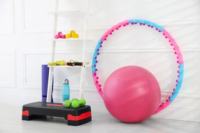 Photo of Different fitness equipment near white wall indoors