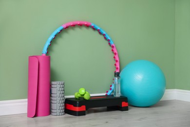 Photo of Different fitness equipment near green wall indoors