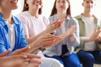 People applauding during meeting indoors, closeup view