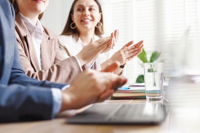 Photo of People applauding at table in office, closeup