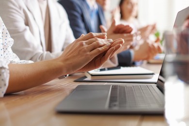 Photo of People applauding at table in office, closeup