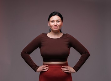 Photo of Plus size woman in gym clothes on grey background