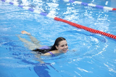 Photo of Beautiful young woman swimming in indoor pool