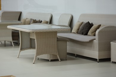 Photo of Stylish table, poufs and sofas in cafeteria