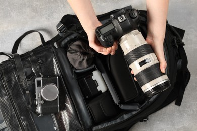 Photographer with professional equipment and backpack at light table, top view