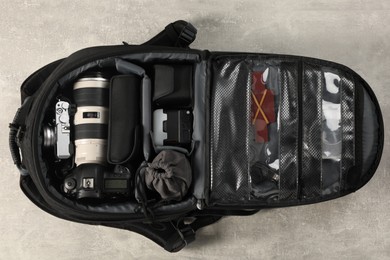 Photo of Professional photographer's equipment in backpack on light table, top view