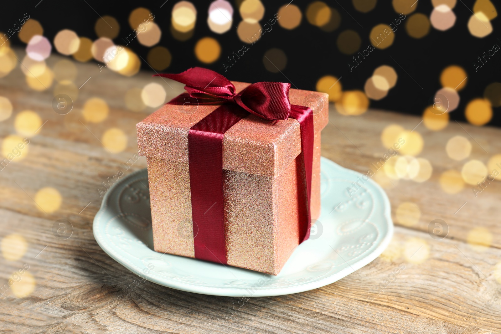 Photo of Romantic gift and plate on wooden table, closeup