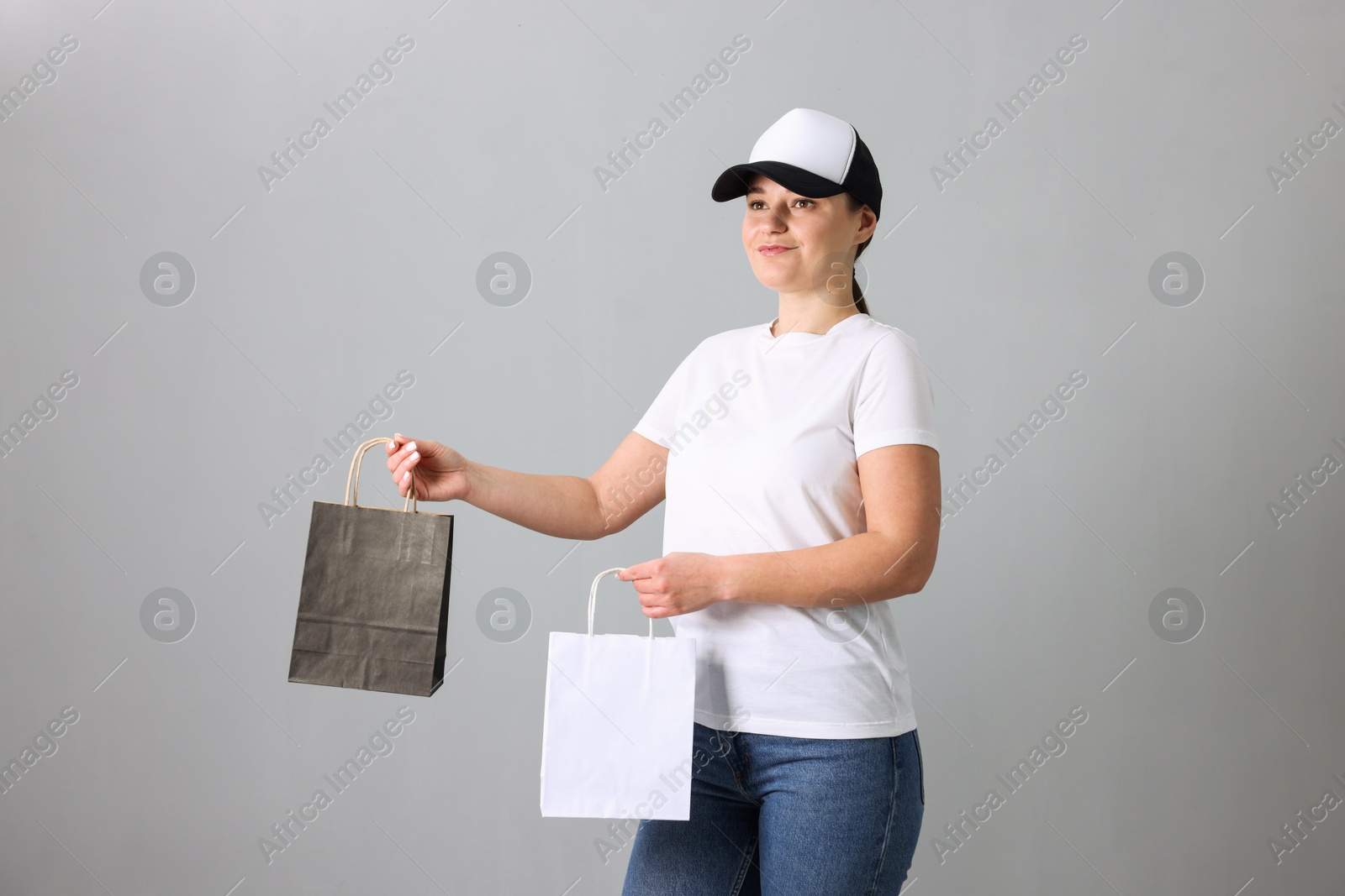 Photo of Woman with blank items for branding on grey background. Mockup for design