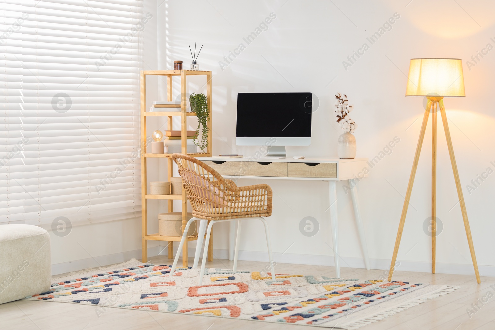 Home office. Comfortable workplace near white wall. Desk with computer and other furniture in room Photo of Home office. Comfortable workplace near white wall. Desk with computer and other furniture in room