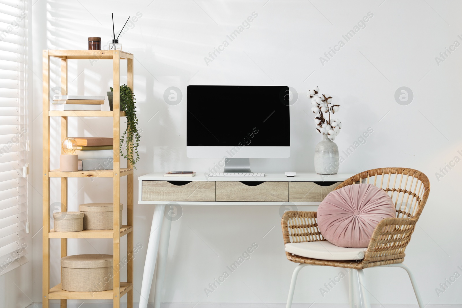 Home office. Comfortable workplace near white wall. Desk with computer and other furniture in room Photo of Home office. Comfortable workplace near white wall. Desk with computer and other furniture in room