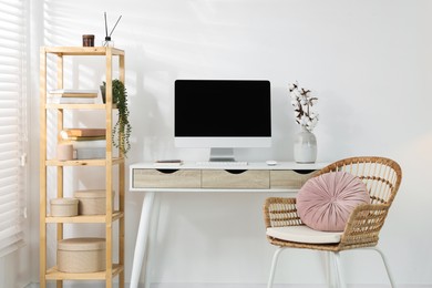 Photo of Home office. Comfortable workplace near white wall. Desk with computer and other furniture in room