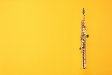 Golden soprano saxophone on yellow background. Space for text