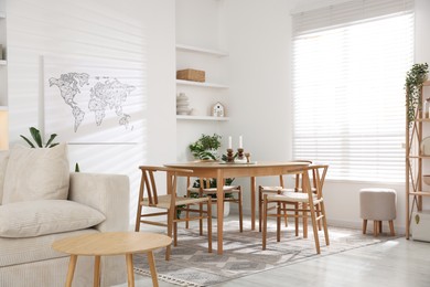 Photo of Stylish wooden table with chairs and decor indoors. Interior design