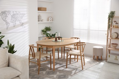 Photo of Stylish wooden table with chairs and decor indoors. Interior design