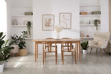 Photo of Stylish wooden table with chairs and decor indoors. Interior design