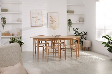 Photo of Stylish wooden table with chairs and decor indoors. Interior design