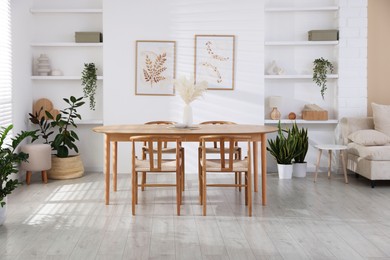 Photo of Stylish wooden table with chairs and decor indoors. Interior design