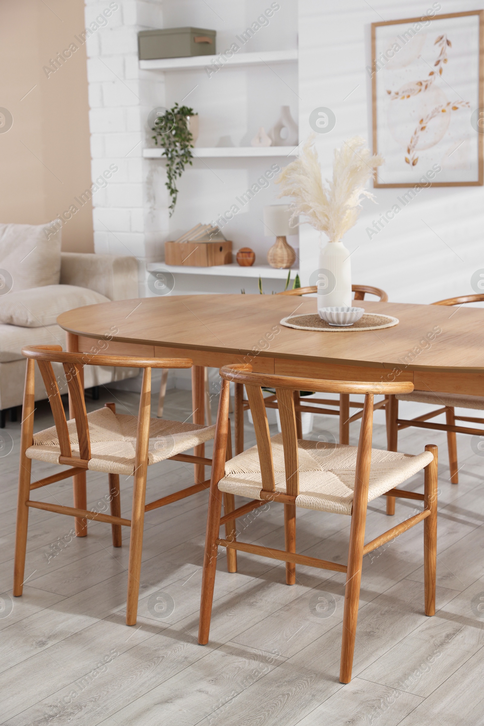 Photo of Stylish wooden table with chairs and decor indoors. Interior design