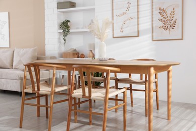 Stylish wooden table with chairs and decor indoors. Interior design