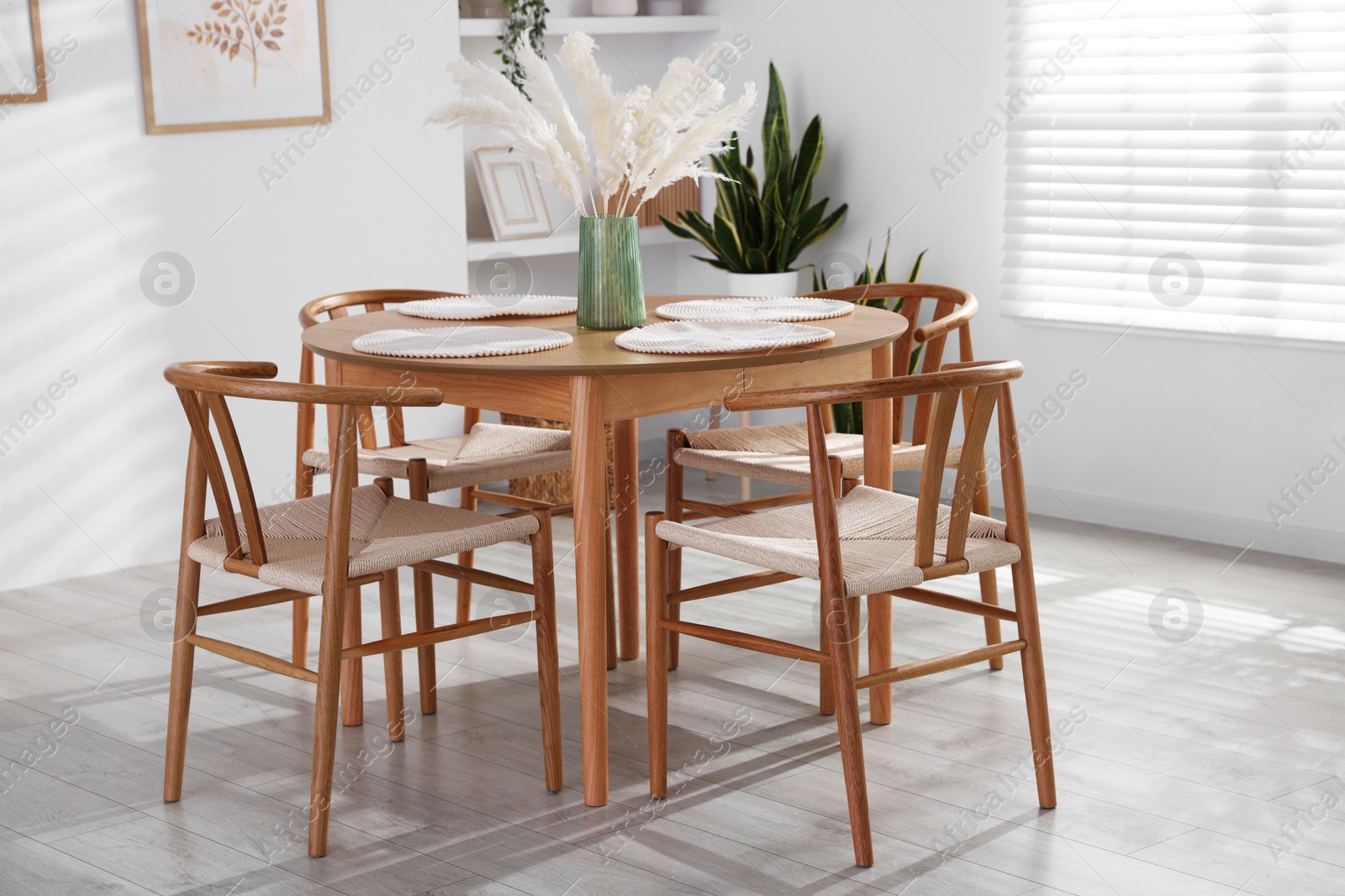 Photo of Stylish wooden table with chairs and decor indoors. Interior design