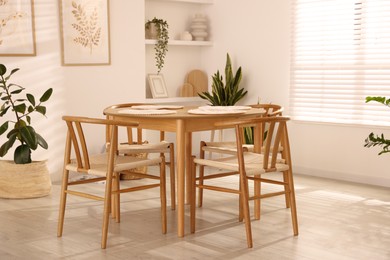 Stylish wooden table with chairs and decor indoors. Interior design