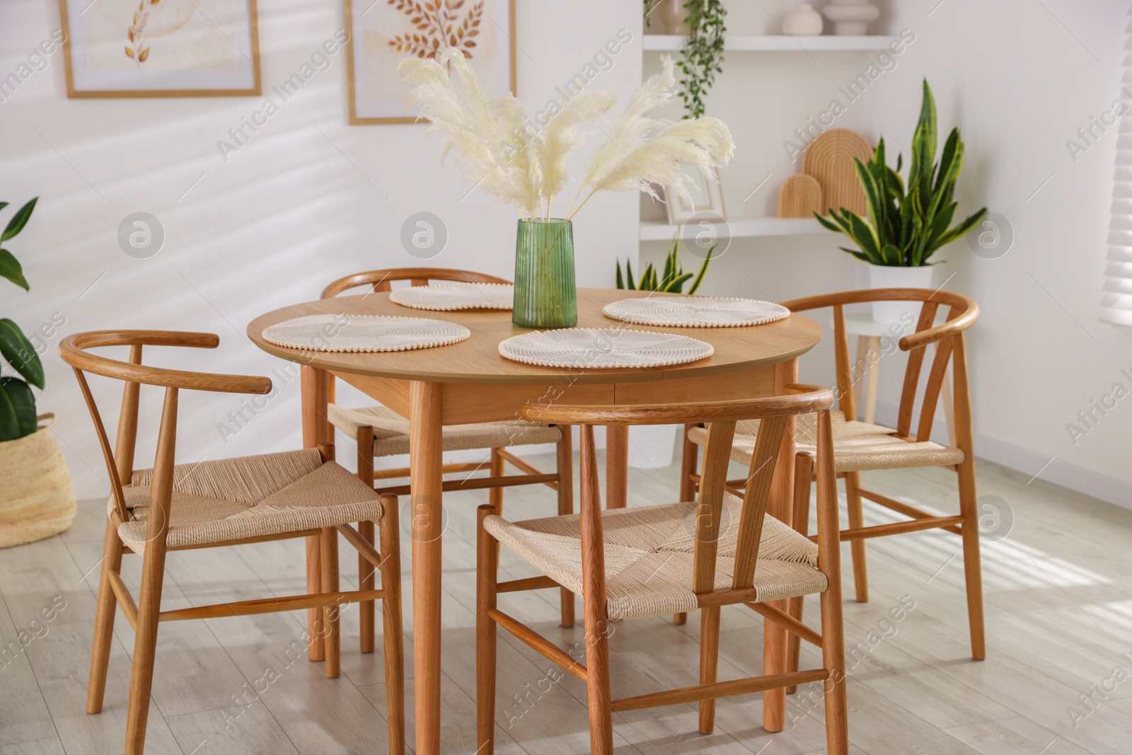 Photo of Stylish wooden table with chairs and decor indoors. Interior design