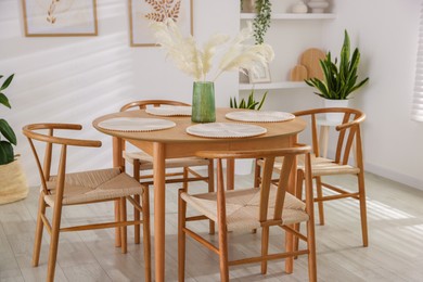 Stylish wooden table with chairs and decor indoors. Interior design