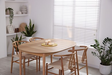 Stylish wooden table with chairs and decor indoors. Interior design