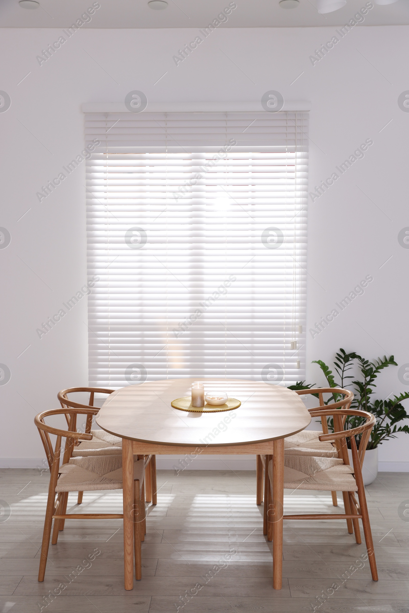 Photo of Stylish wooden table with chairs and decor indoors. Interior design