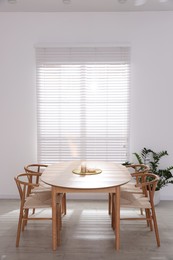 Stylish wooden table with chairs and decor indoors. Interior design